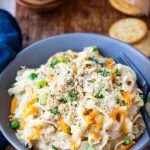 Blue dish of instant pot tuna noodle casserole on a wooden cutting board