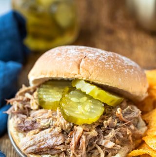 Instant pot honey mustard pork on a bun topped with pickle slices
