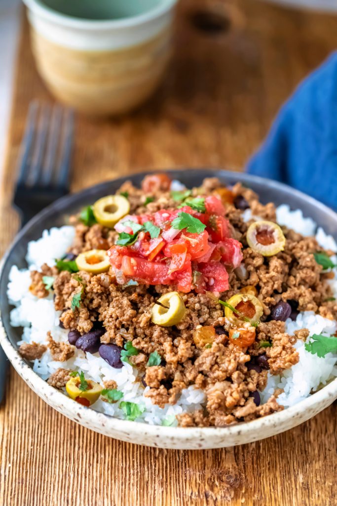Plate of instant pot beef picadillo on a wooden cutting board