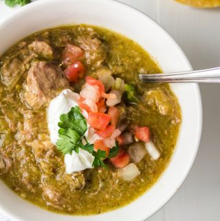 White bowl with pork chile verde in it