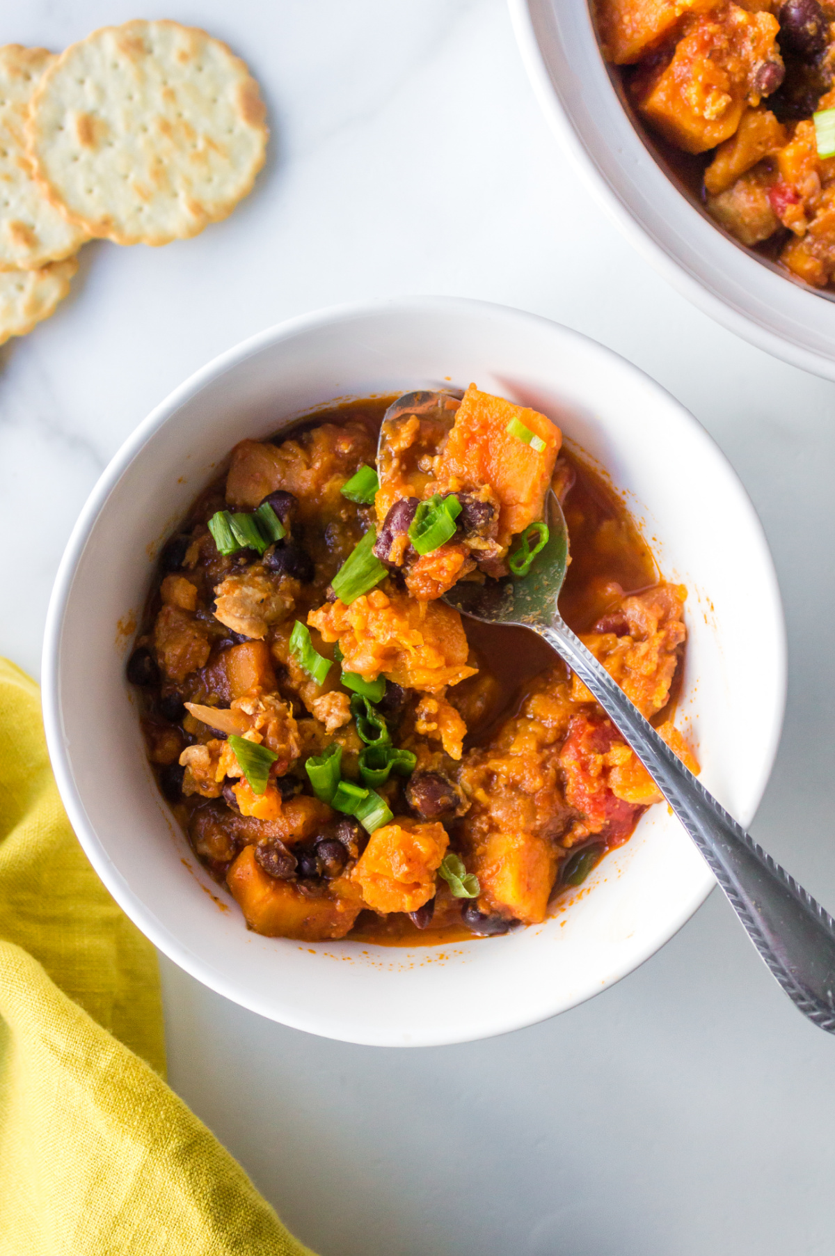 Bowl of Instant Pot turkey black bean sweet potato chili with a spoon in it