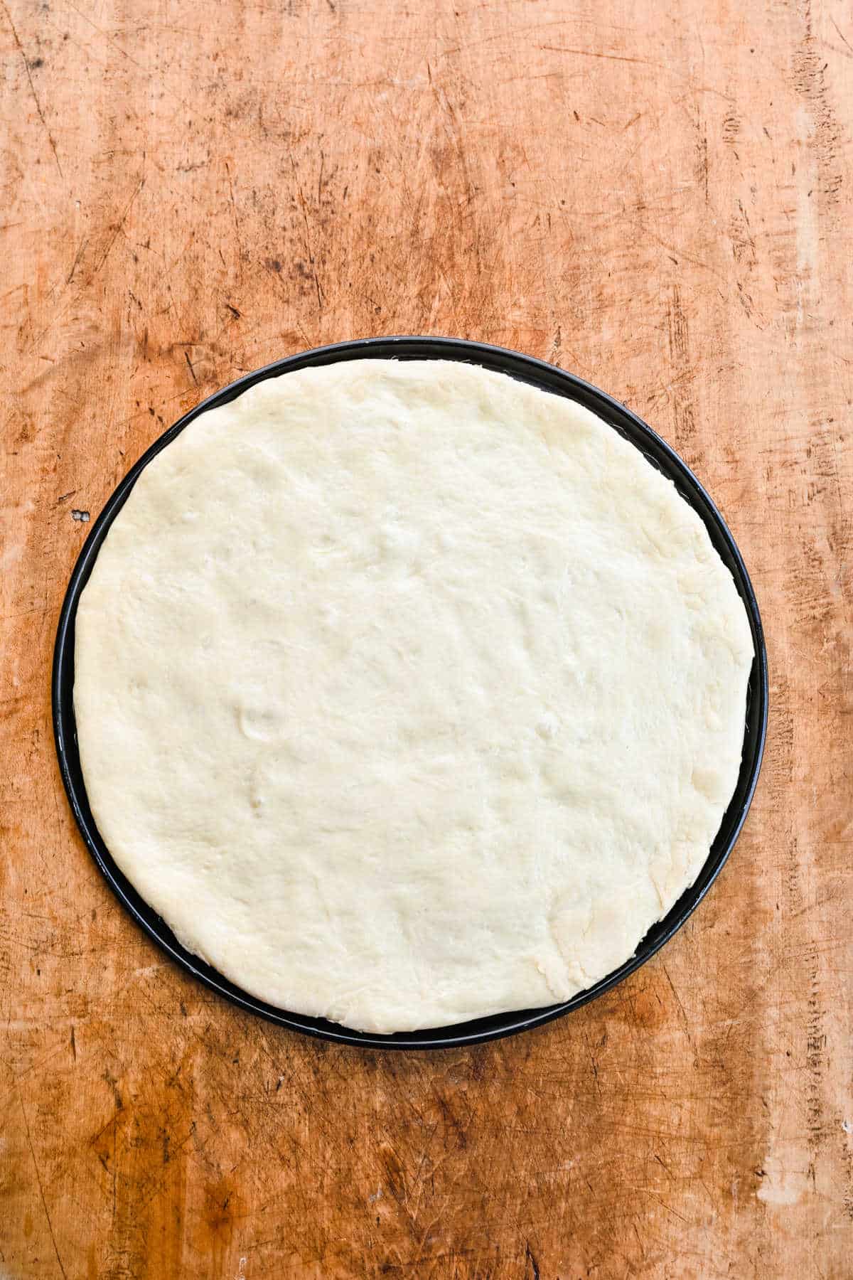 Pizza dough rolled out into a circle. 