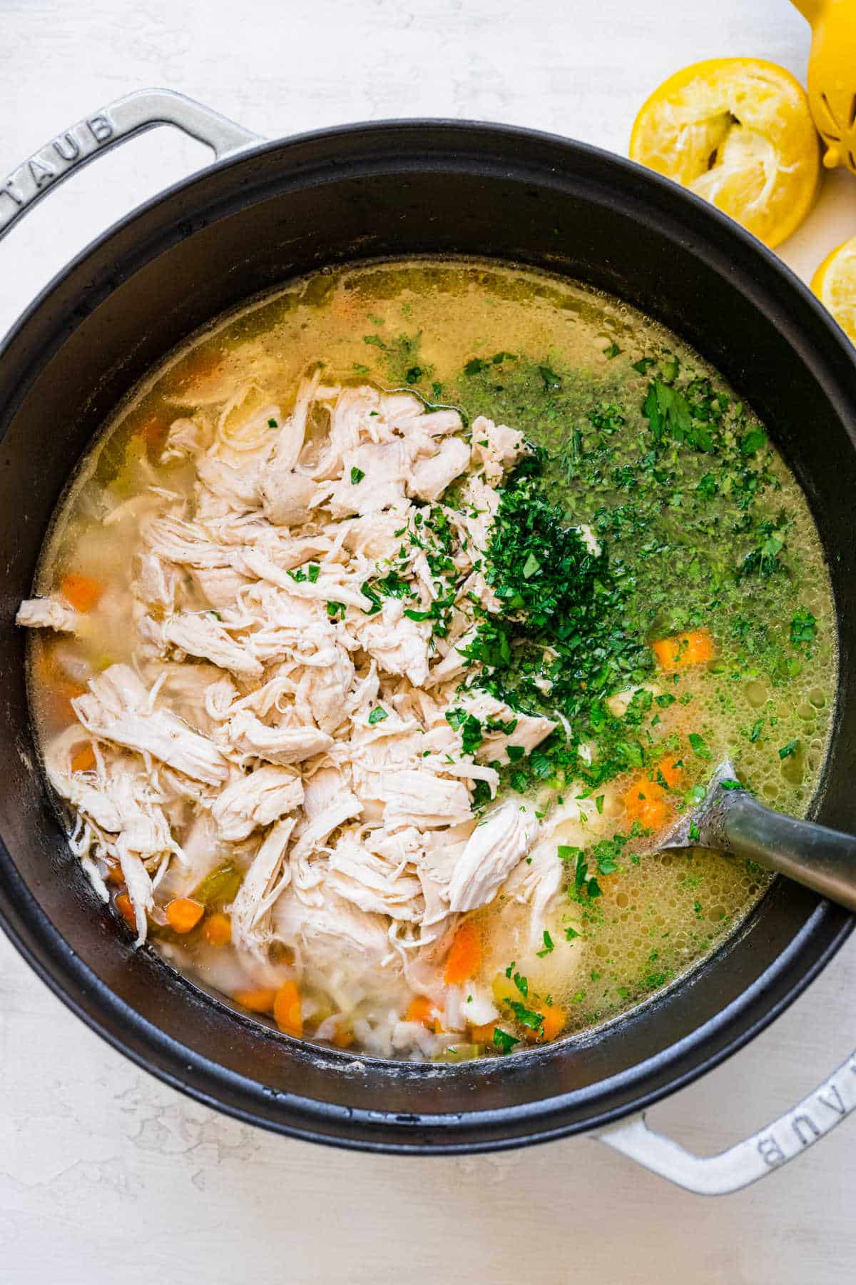 Added chicken parsley and dill to a pot oflemon chicken and rice soup.
