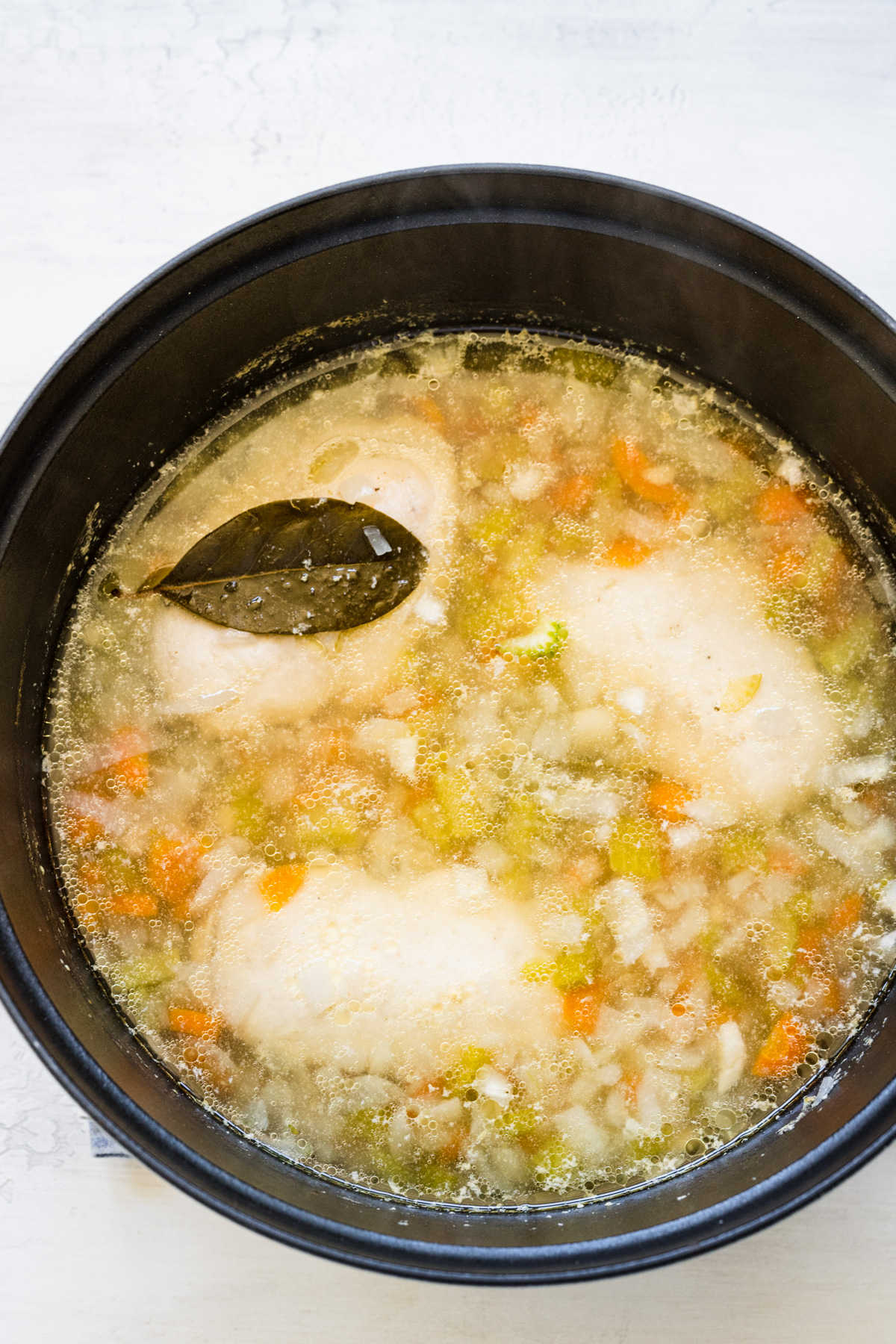 Rice and butter added to pot of lemon chicken and rice soup.