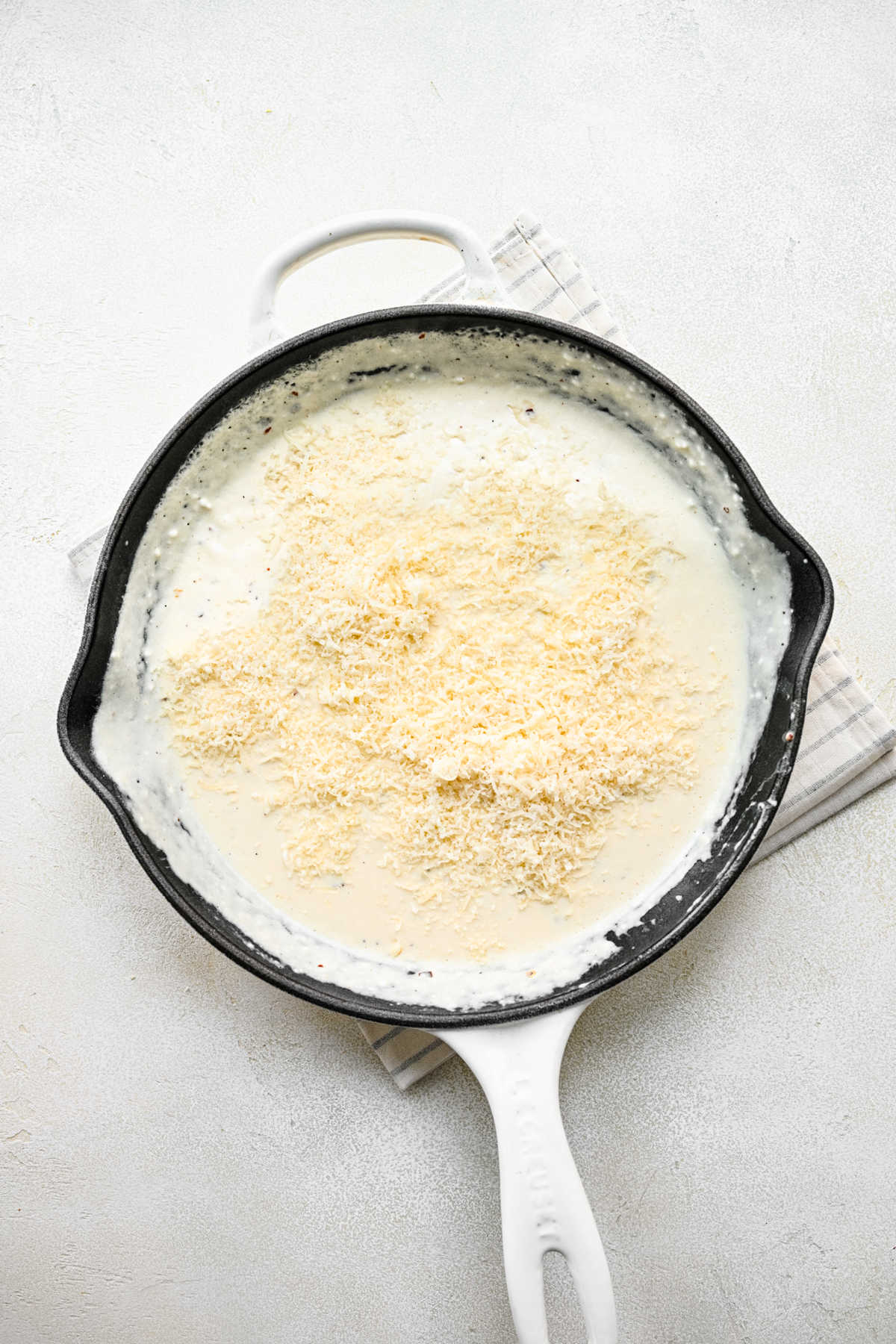 Parmesan cheese and lemon juice on top of cream cheese mixture in a skillet. 