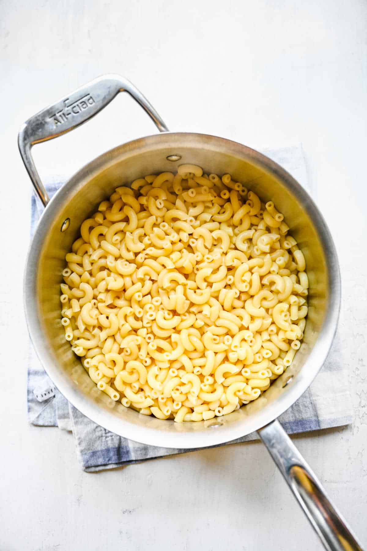 A pot full of cooked and drained macaroni.