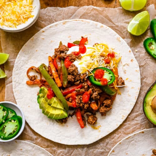 Ground beef fajitas topped with cheese avocado and jalapeno on a flour tortilla.