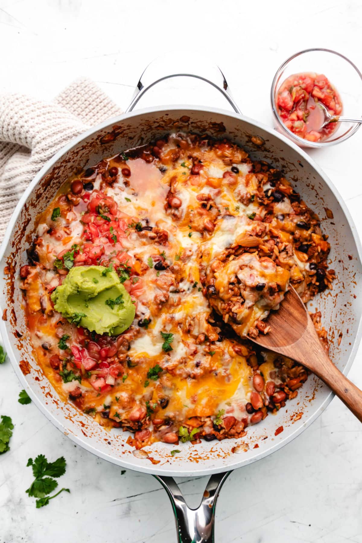 Mexican beef and rice skillet topped with a scoop of guacamole. 